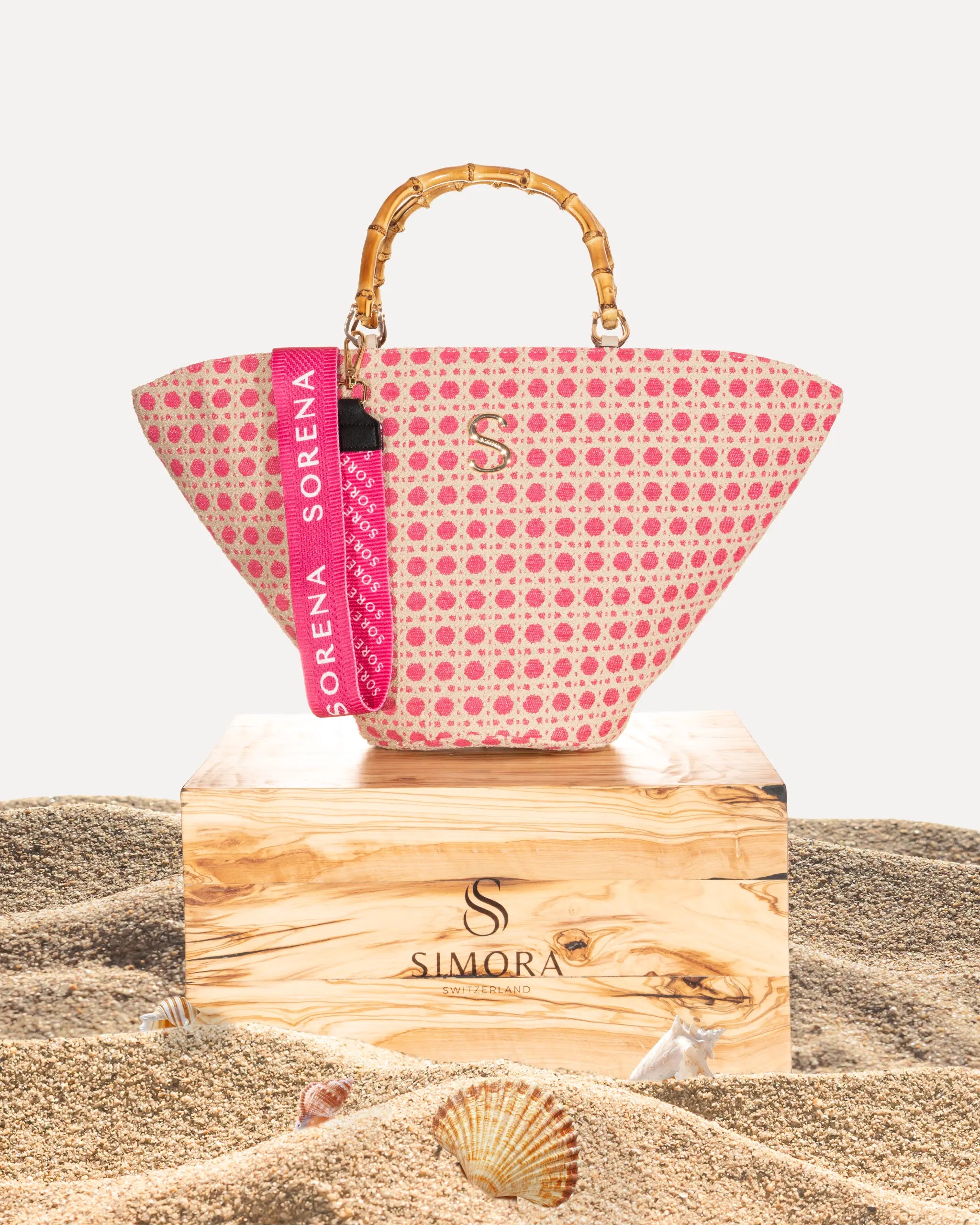 Sorena Greece Coralina Medium Basket Bag auf SIMORA Olivenholzsockel Frontansicht, Korbform Coralina handgefertigt Griechenland