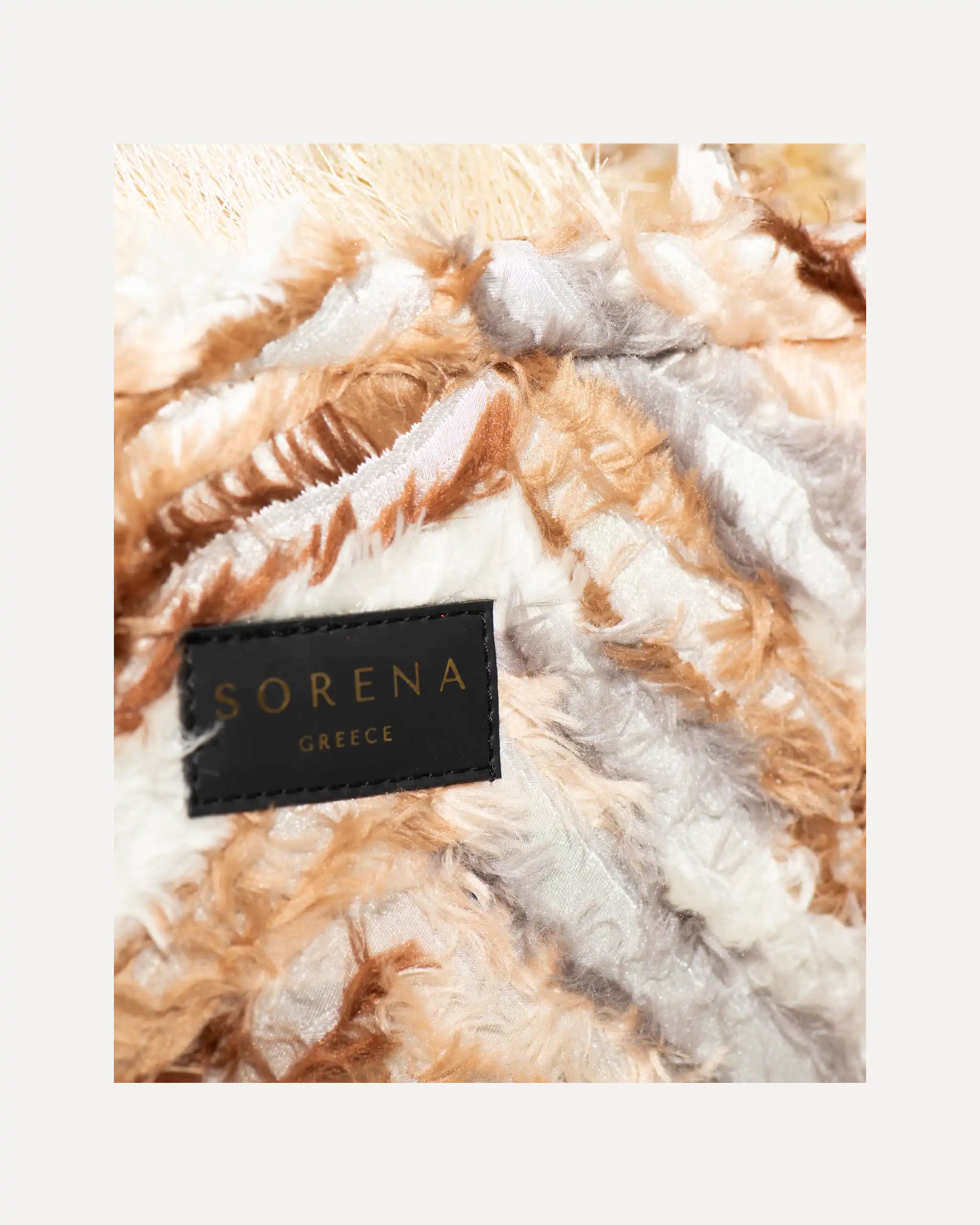 Detailansicht der Sorena Greece Tote Bag – strukturierte Oberfläche mit federartiger Textur in Beige und Braun, Label „SORENA GREECE“, vertikales Band mit Branding, perfekte tote bag mit Federoptik für Business & Freizeit, handtaschen damen mit Statement.