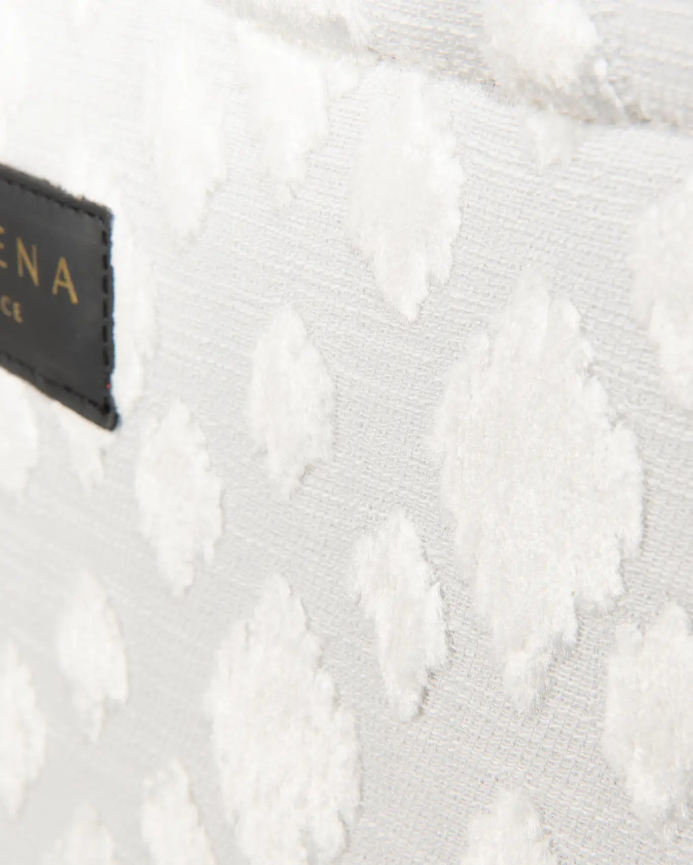 Nahaufnahme Milos Medium Tote Sorena Greece, Bouclé Struktur Creme Tufted Punkte dreidimensionale Textur Detailansicht handgefertigtes Gewebe.
