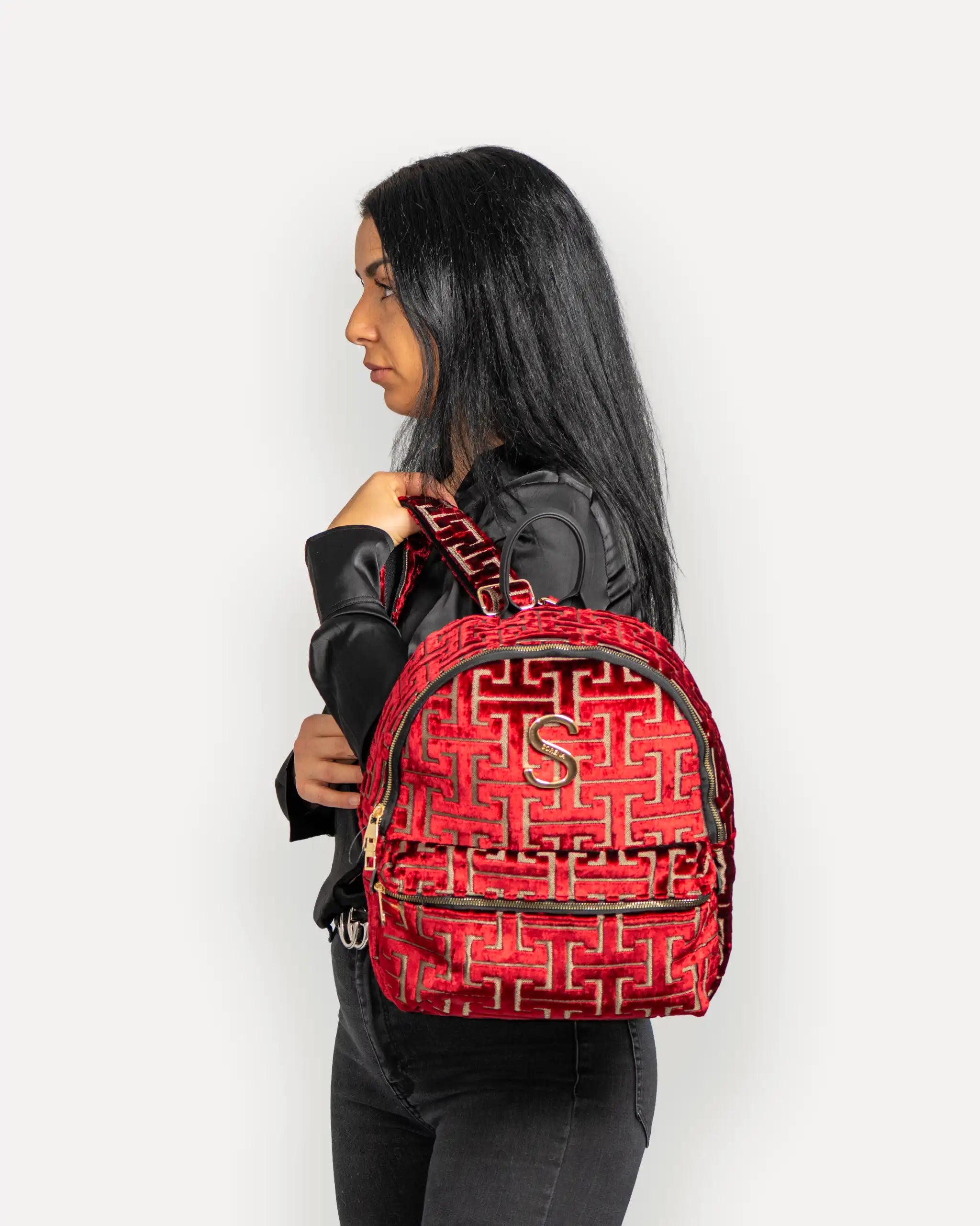 Model mit SORENA Designer Rucksack in Rot-Velvet – veganer rucksack für Damen, handgemacht mit mediterranem Flair. Stylische rucksäcke nachhaltig schweiz mit schneller Lieferung.