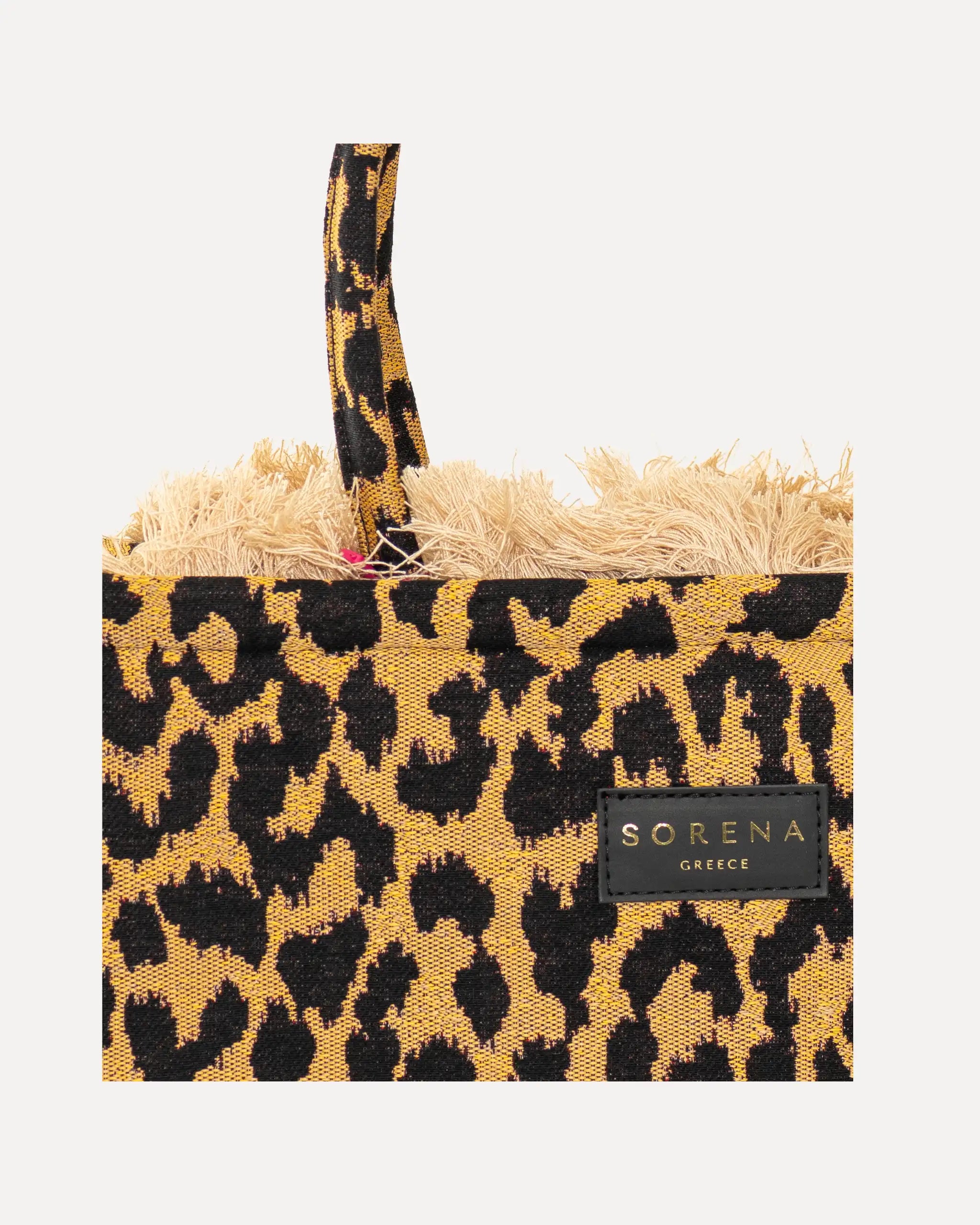 Frontansicht Nachaufmahme der Sorena Greece Medium Tote Bag – Leopard-Muster in Gelb und Schwarz, Fransen, Label und vertikales Branding sichtbar, hochwertige shopper tasche damen schweiz mit Designfokus.