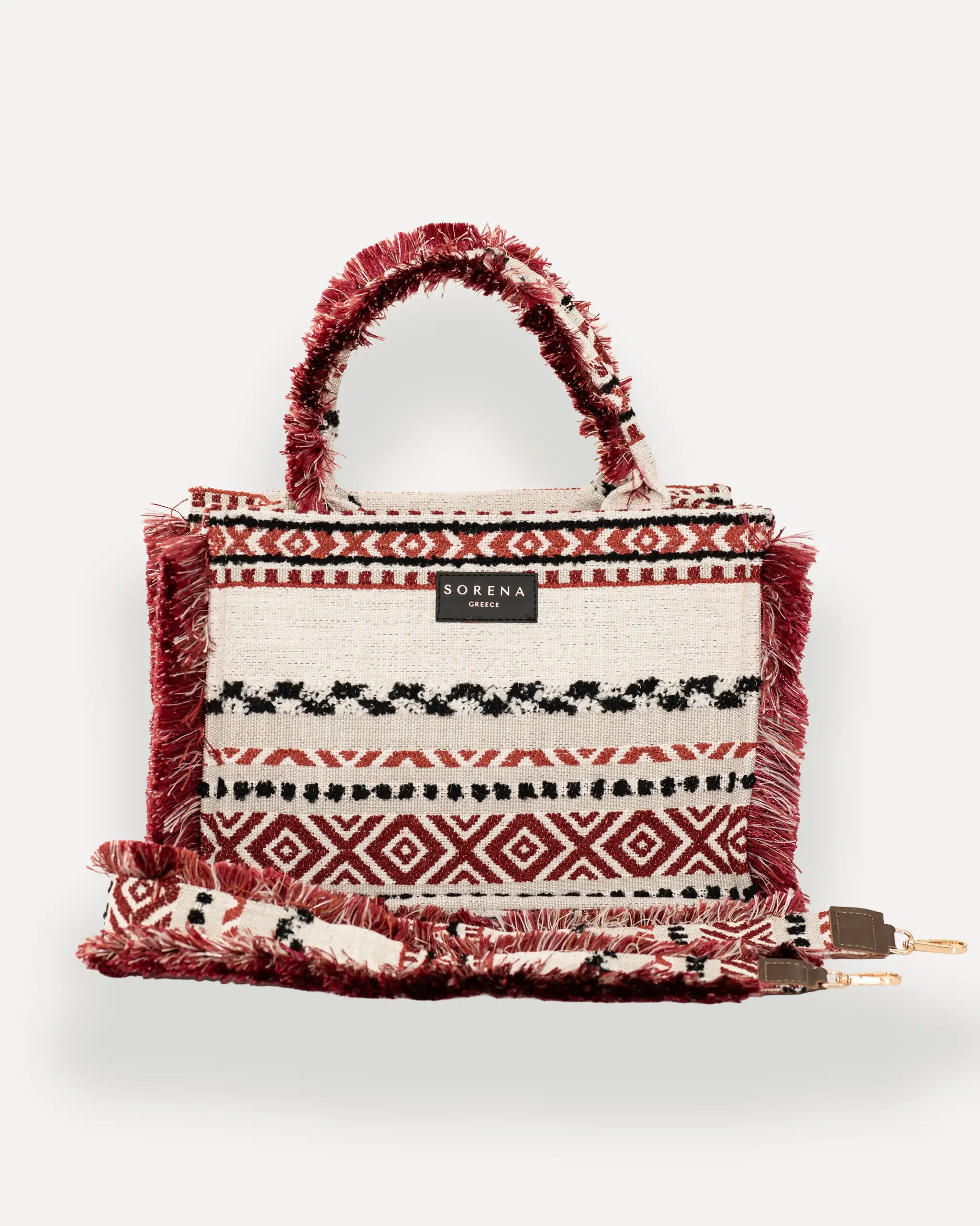 Frontansicht der Sorena Greece Large Tote Bag – tribal-inspiriertes Muster in warmen Tönen, Fransen, Label und goldfarbene Details sichtbar, hochwertige shopper tasche damen schweiz mit Designfokus.
