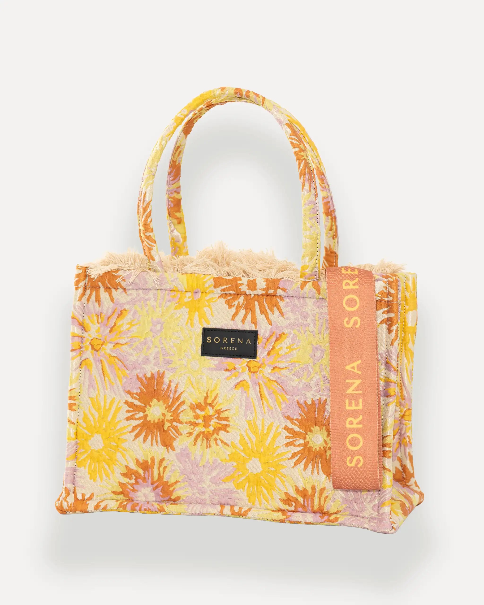 Sorena Greece Medium Tote Bag linksseitig getragen – elegante tote bag mit Fransen und vertikalem „SORENA“-Band, ideal als shopper bag für City-Looks, tote bag rot mit sommerlichem Charakter.