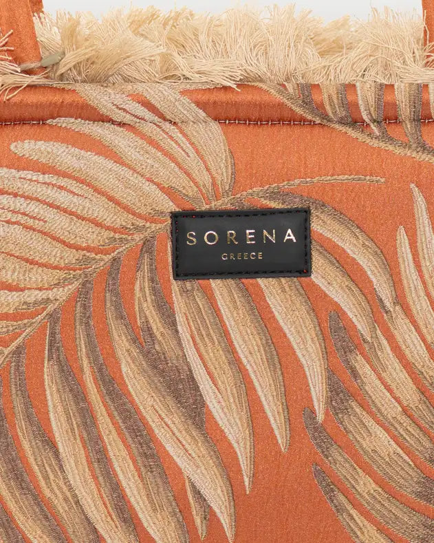 Detailansicht der Sorena Greece Large Tote Bag – strukturierte Oberfläche mit Blatt-Print in Orange und Beige, Label „SORENA GLIDES“, vertikales Band mit Branding, perfekte tote bag für Business & Freizeit, tasche mit swiss trust und garantie.