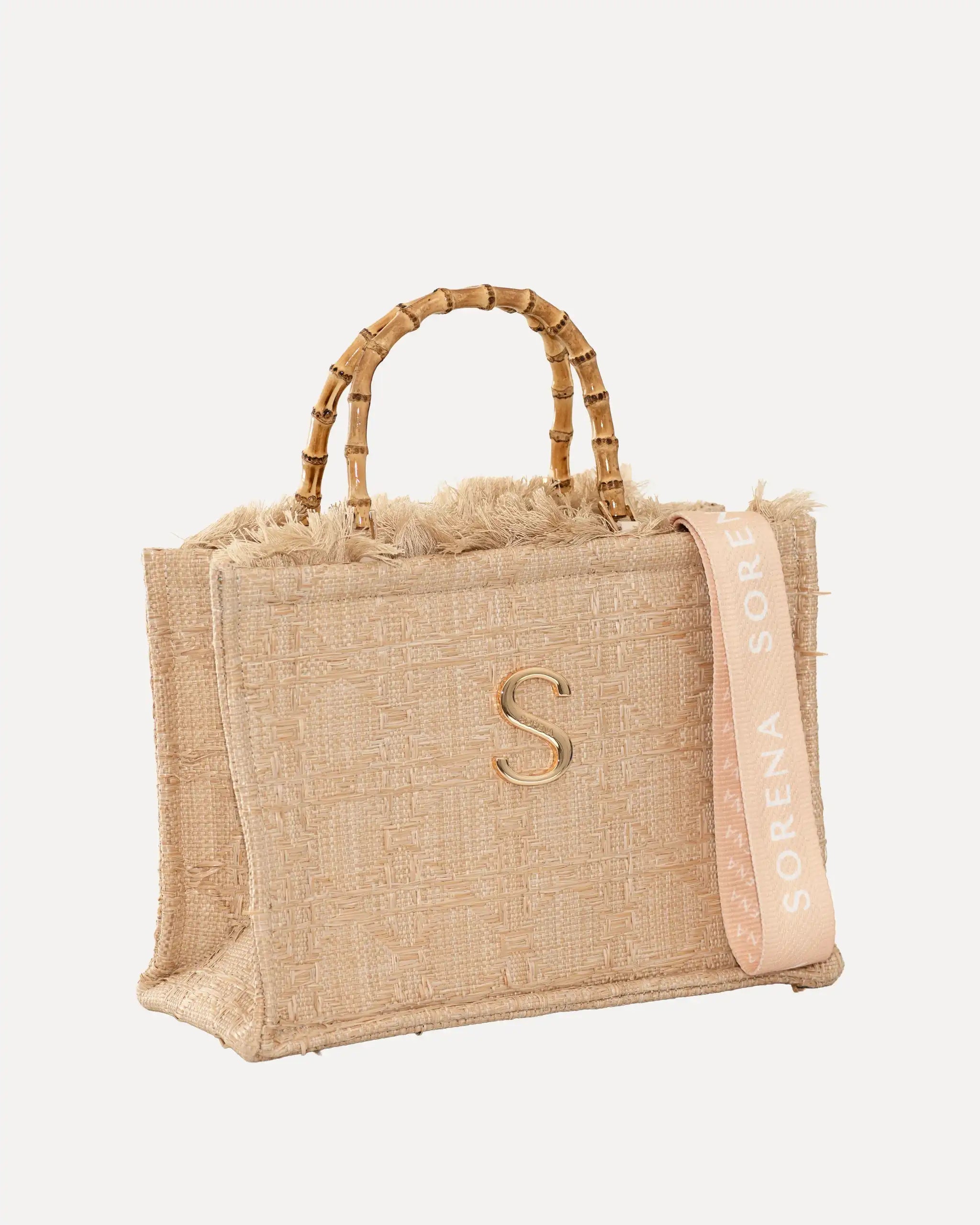 Female Model mit Sorena Greece Tote Bag rechtsseitig getragen – stylische tote bag beige mit Bambusgriffen und „S“-Emblem, perfekte handtasche für City-Looks, limitierte designer bags schweiz.