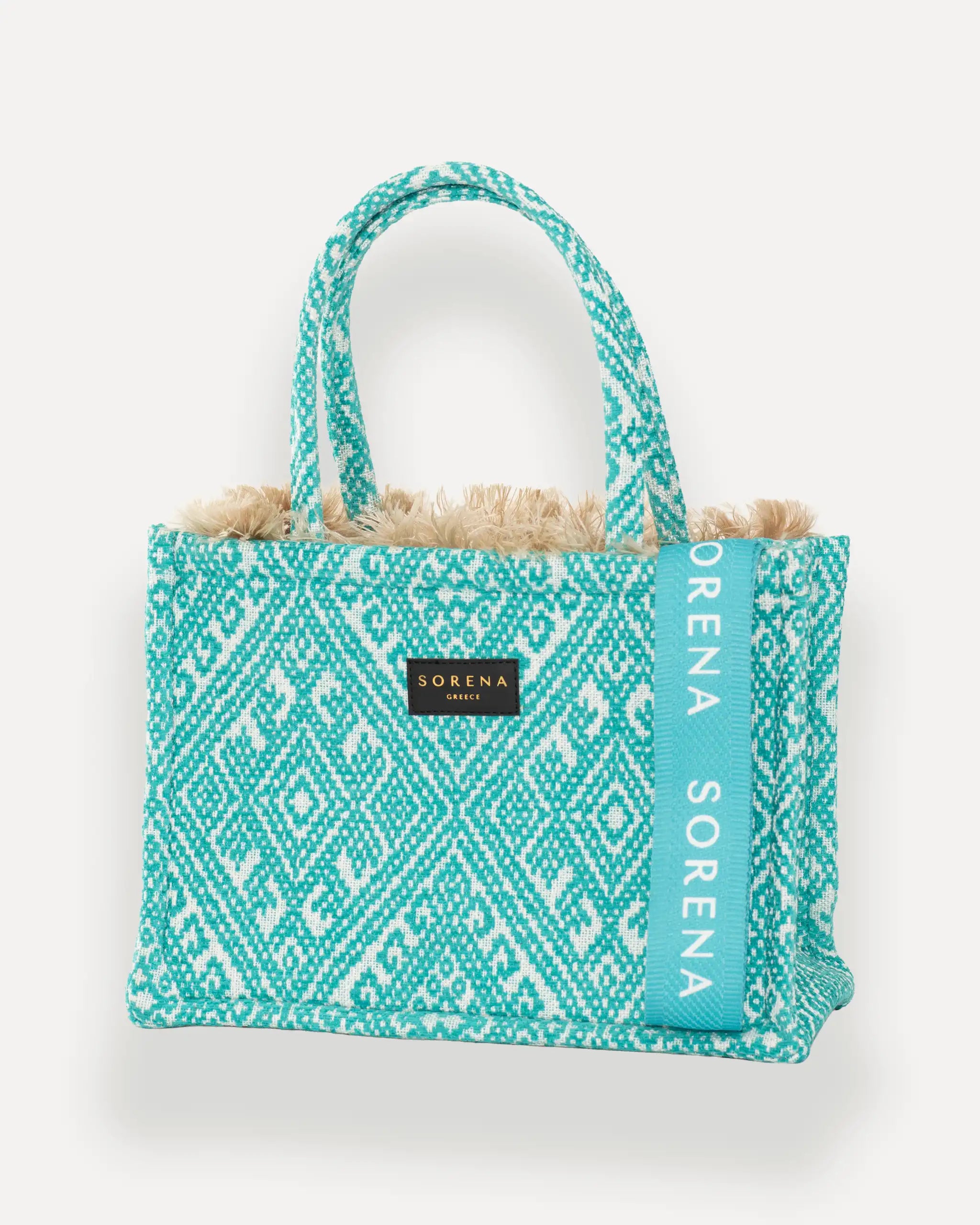 Sorena Greece Medium Tote Bag linksseitig getragen – elegante tote bag mit Fransen und vertikalem „SORENA“-Band, ideal als shopper bag für City-Looks, tote bag blau für Sommer und Alltag.