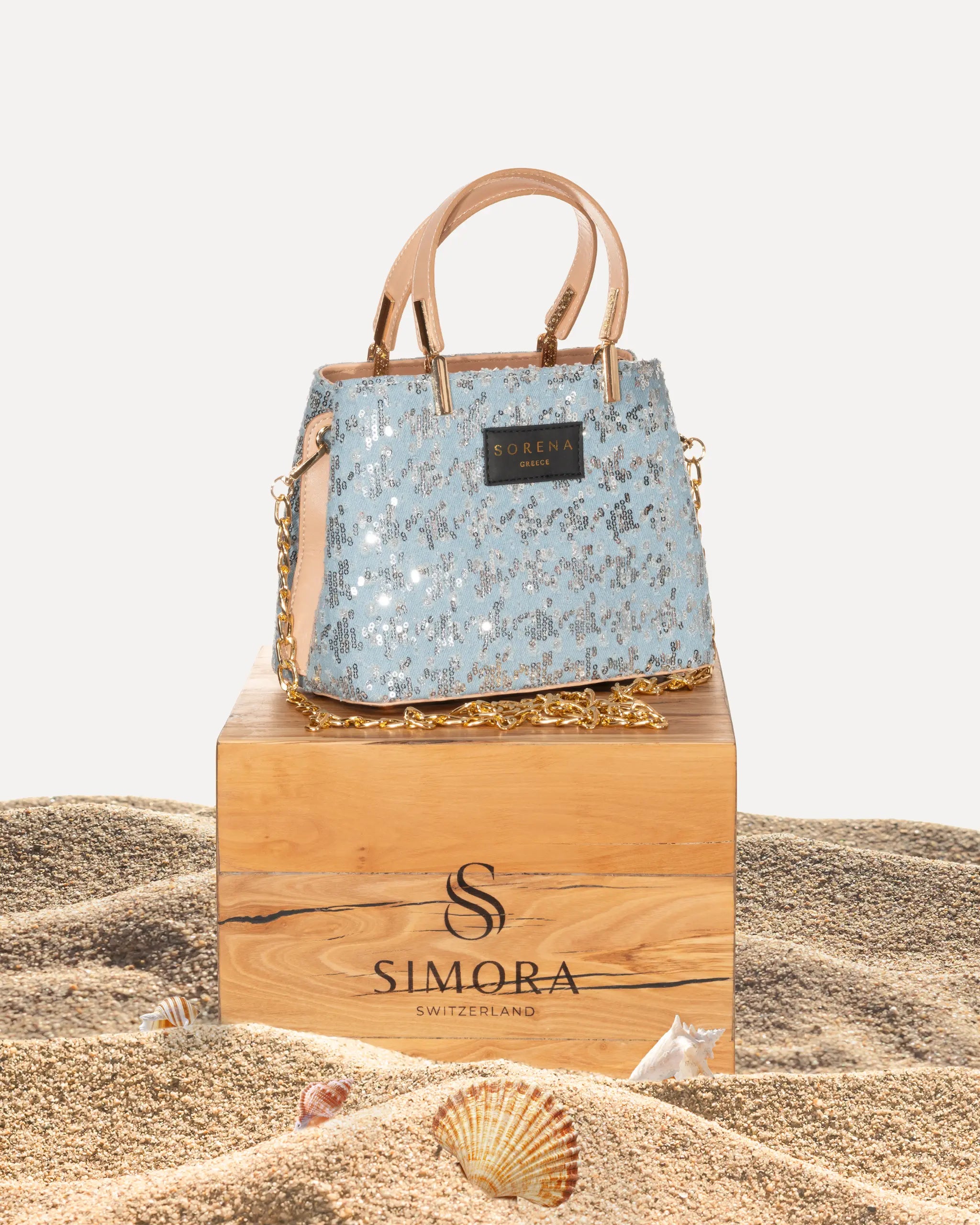 Sorena Greece Galleria Bag Tritiani Edition auf SIMORA Olivenholzsockel Frontansicht, vollflächige Pailletten Silber irisierend Galleria Tasche handgefertigt