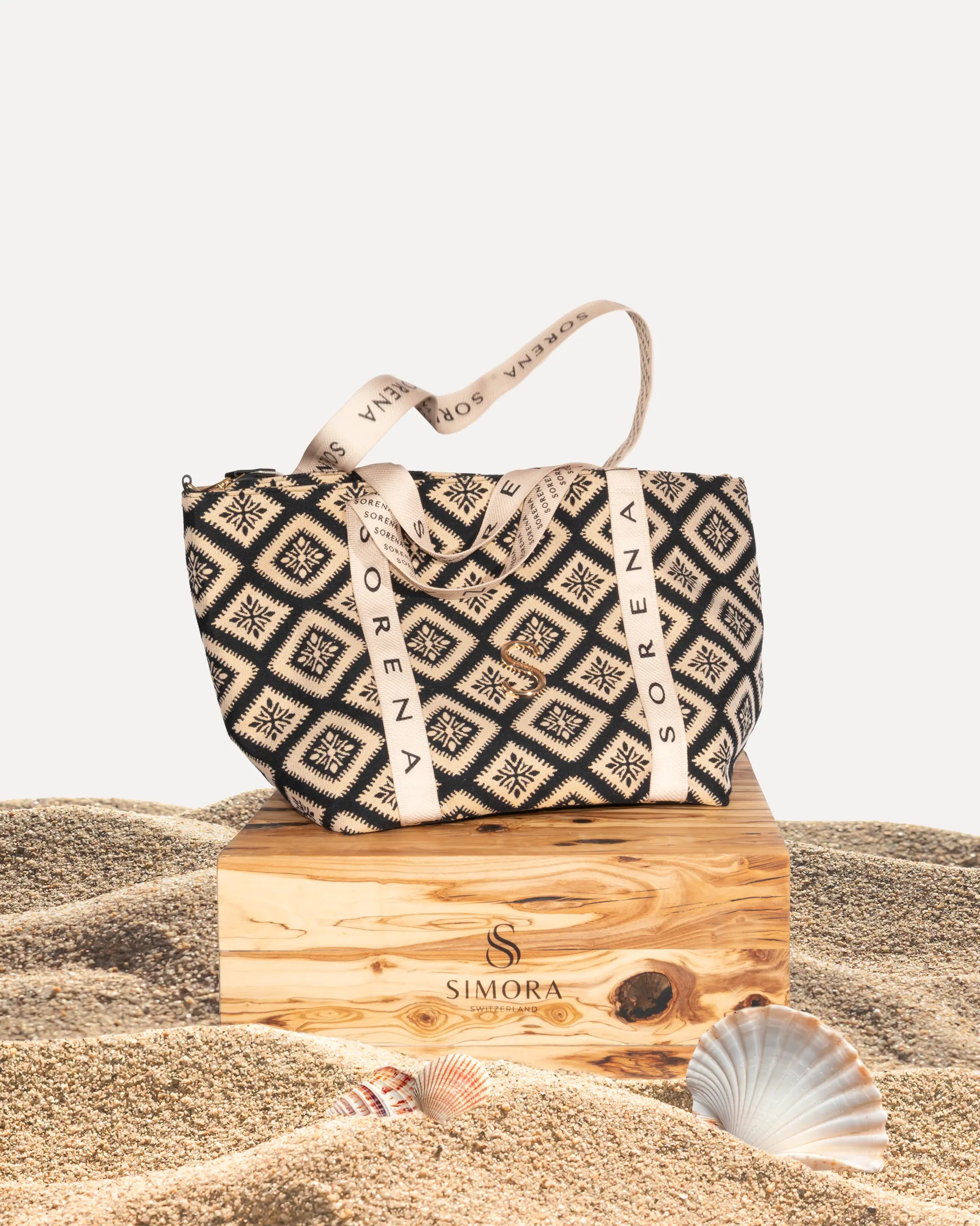 Sorena Greece Cycladitissa Traveller Bag auf SIMORA Olivenholzsockel, Frontansicht großformatige Reisetasche Jacquard Schwarz Beige Reißverschluss handgefertigt