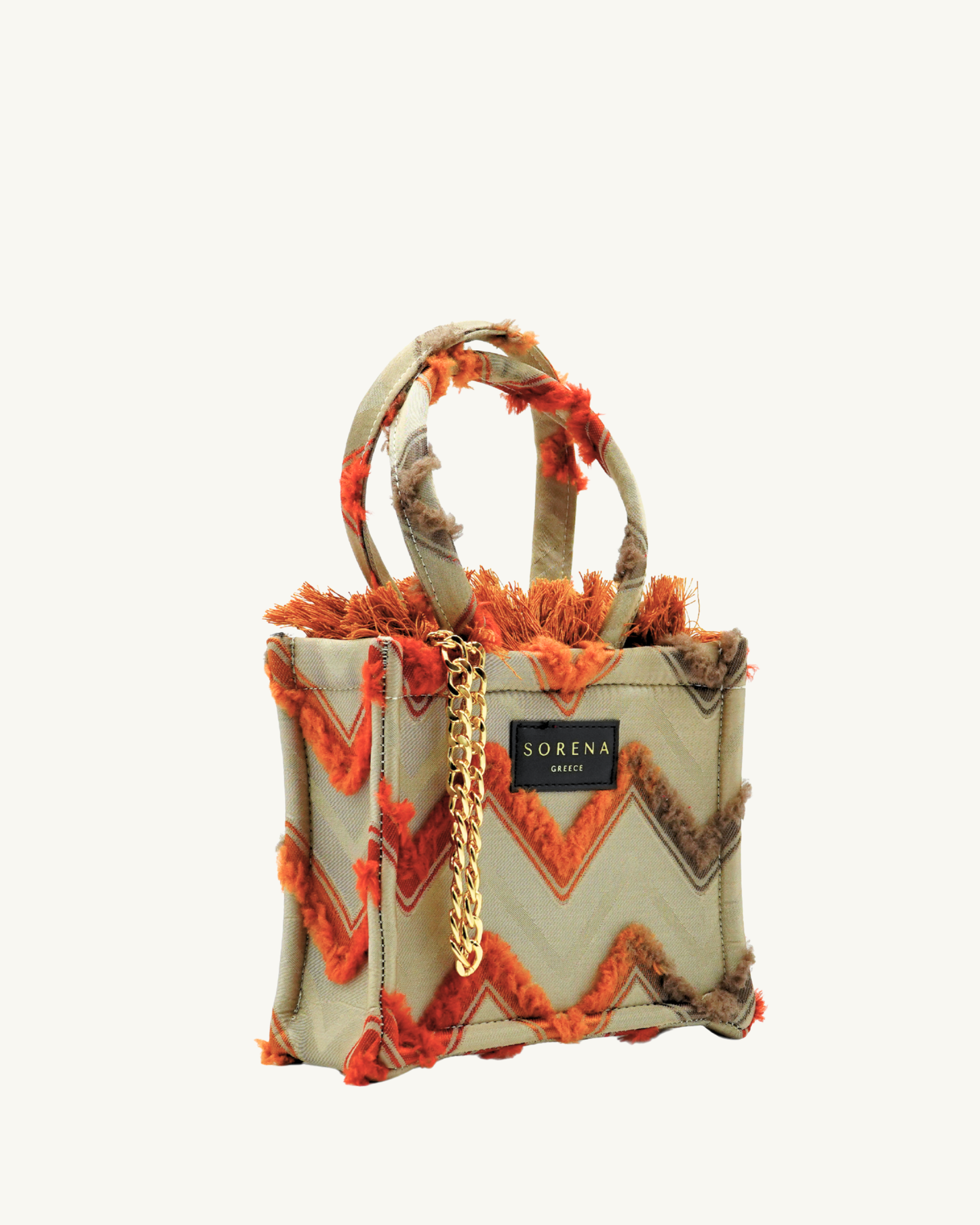 Seitliche Ansicht der handgemachten SORENA Mini-Tasche KATRINA in Orange-Beige-Gold – geometrisches Design, nachhaltig kuratiert von SIMORA