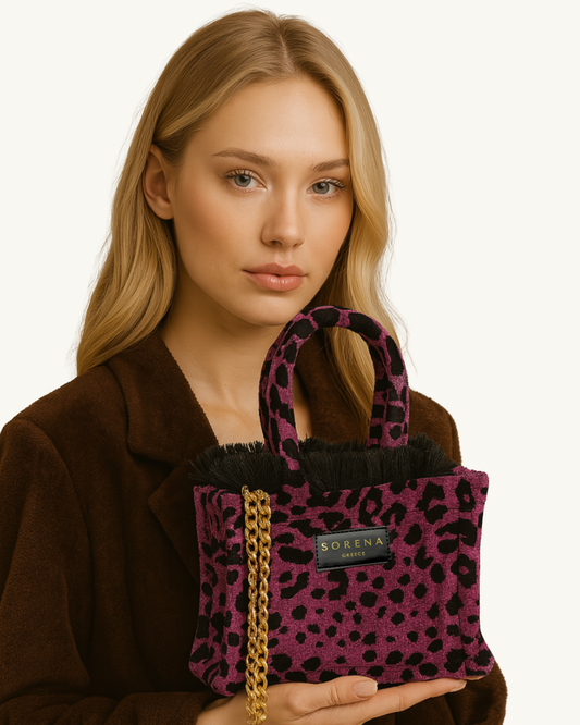 Model trägt die handgemachte SORENA Mini-Tasche mit Leopardmuster in Magenta-Schwarz-Gold – nachhaltiges Statement-Piece aus dem SIMORA-Shop