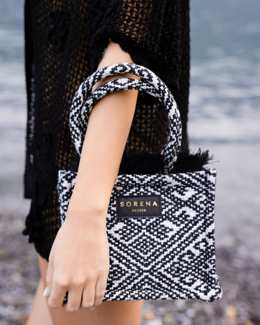 Model trägt die nachhaltige SORENA Mini-Tasche ROXANI mit geometrischem Muster in Hellblau-Gold – handgemachtes Statement-Piece aus dem SIMORA-Shop