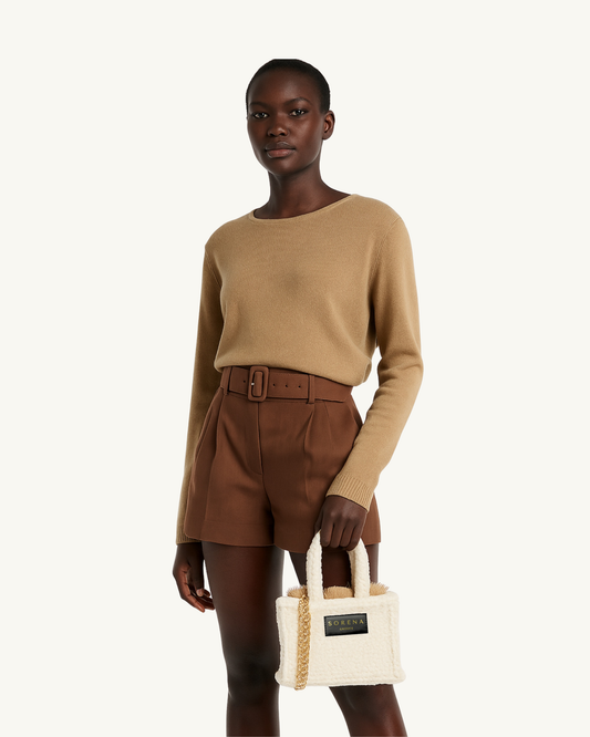 Model trägt die handgemachte SORENA Mini-Tasche TEDDY in Hellbeige-Gold – stilvolles, nachhaltiges Accessoire mit flauschiger Struktur aus dem SIMORA-Shop
