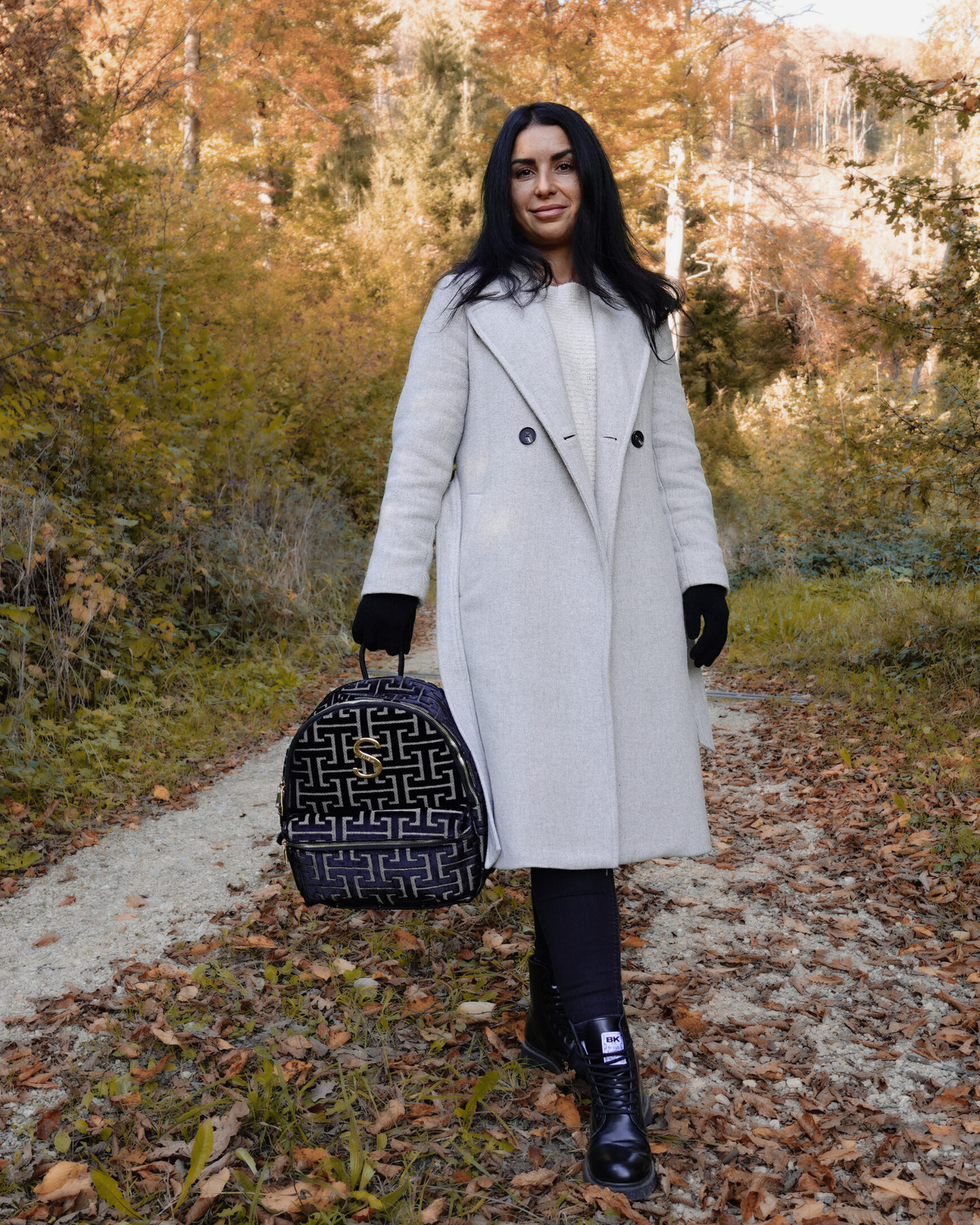 Model trägt nachhaltigen SORENA-Rucksack ANDRO in schwarz-gold – stilvolles Statement-Piece mit geometrischem Muster aus dem SIMORA-Shop