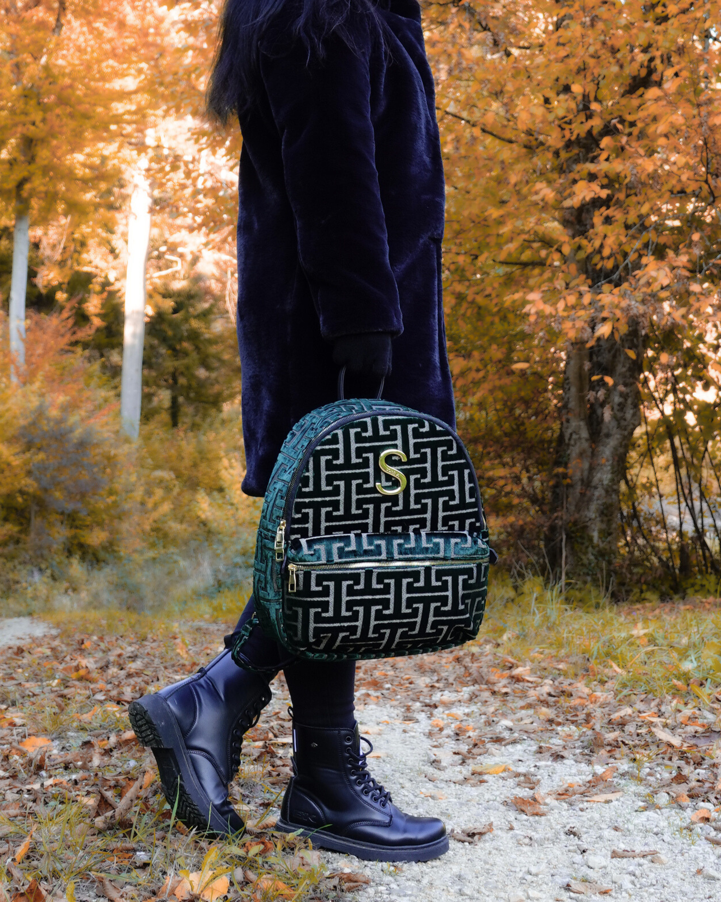 Model trägt nachhaltigen SORENA-Rucksack NAFSIKA in grün-gold – stilvolles Statement-Piece mit geometrischem Muster aus dem SIMORA-Shop