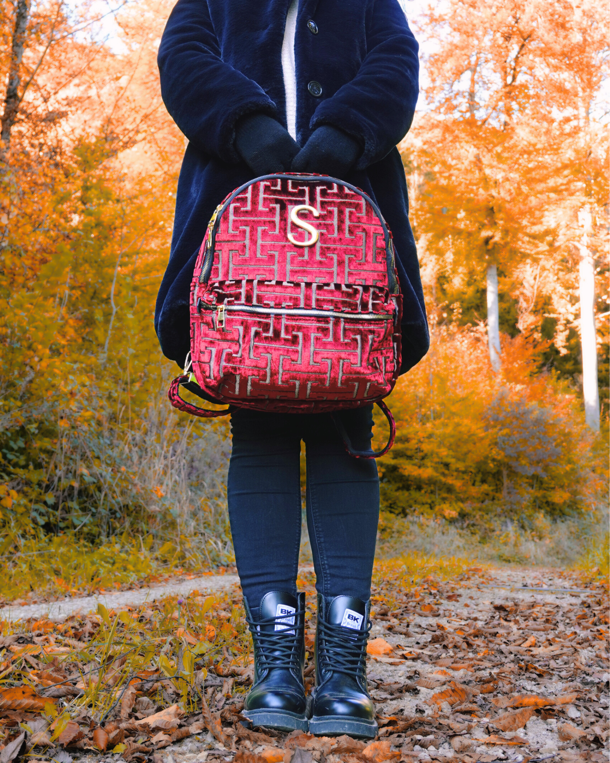 Model trägt handgemachten SORENA-Rucksack in rot-gold – nachhaltiges Statement-Piece aus dem SIMORA-Shop im herbstlichen Outdoor-Look