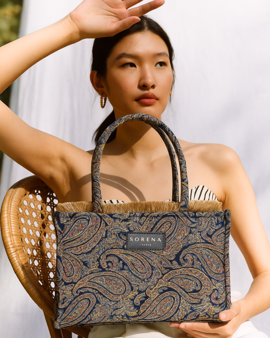 Model trägt die handgemachte SORENA CLEIO Shopper mit kunstvollem Paisley-Muster – vegane, nachhaltige Tasche für stilvolle Alltagsmomente und mediterrane Eleganz.