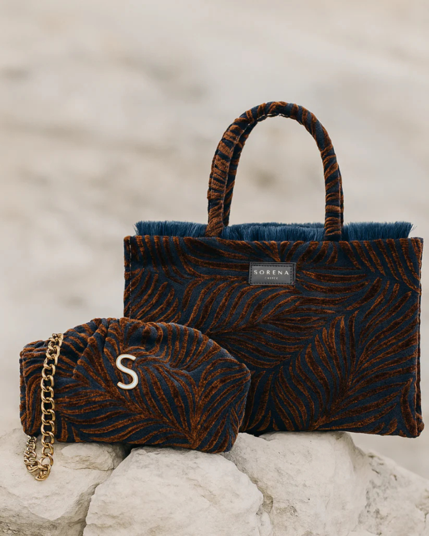 Mehrere handgemachte SORENA DOROTHY Shopper in herbstlichem Dunkelrot – vegane, nachhaltige Taschen inszeniert in einer natürlichen Steinumgebung, stilvoll gruppiert für visuelle Tiefe und Markencharisma.