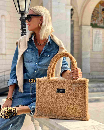 Sitzendes Model mit der handgemachten SORENA TEDDY HONEY Shopper in Beige – flauschige, vegane Tasche aus nachhaltiger Herstellung, lässig getragen für stilvolle Herbstmomente.