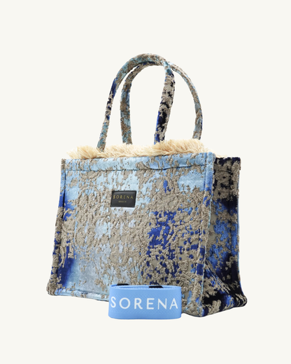 Seitenansicht der handgemachten SORENA THALASSINI Shopper – vegane, nachhaltige Tasche mit wellenförmigem Muster und klarer Silhouette in Blau-Sand.