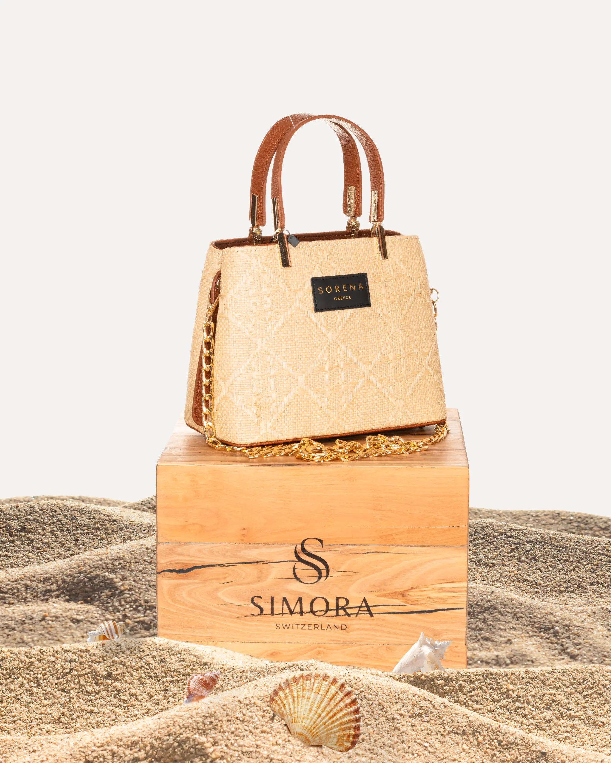 Sorena Greece Galleria Bag Irida Edition auf SIMORA Olivenholzsockel Frontansicht, Naturstroh Galleria Form goldfarbene Details handgefertigt