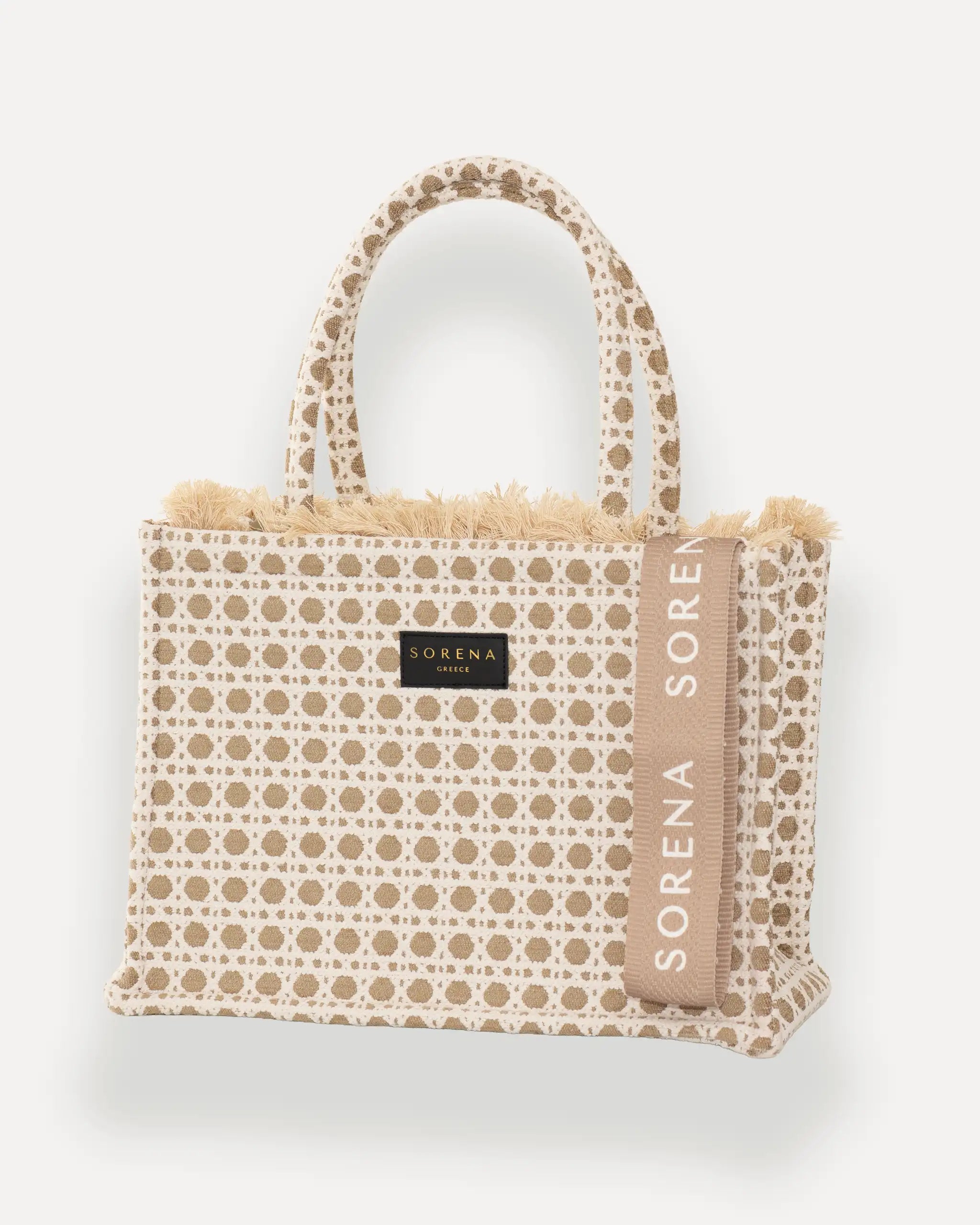 Sorena Greece Medium Tote Bag linksseitig getragen – tote bag beige mit Fransen und vertikalem „SORENA“-Band, ideal als shopper bag für City-Looks, bags schweiz mit Designfokus.