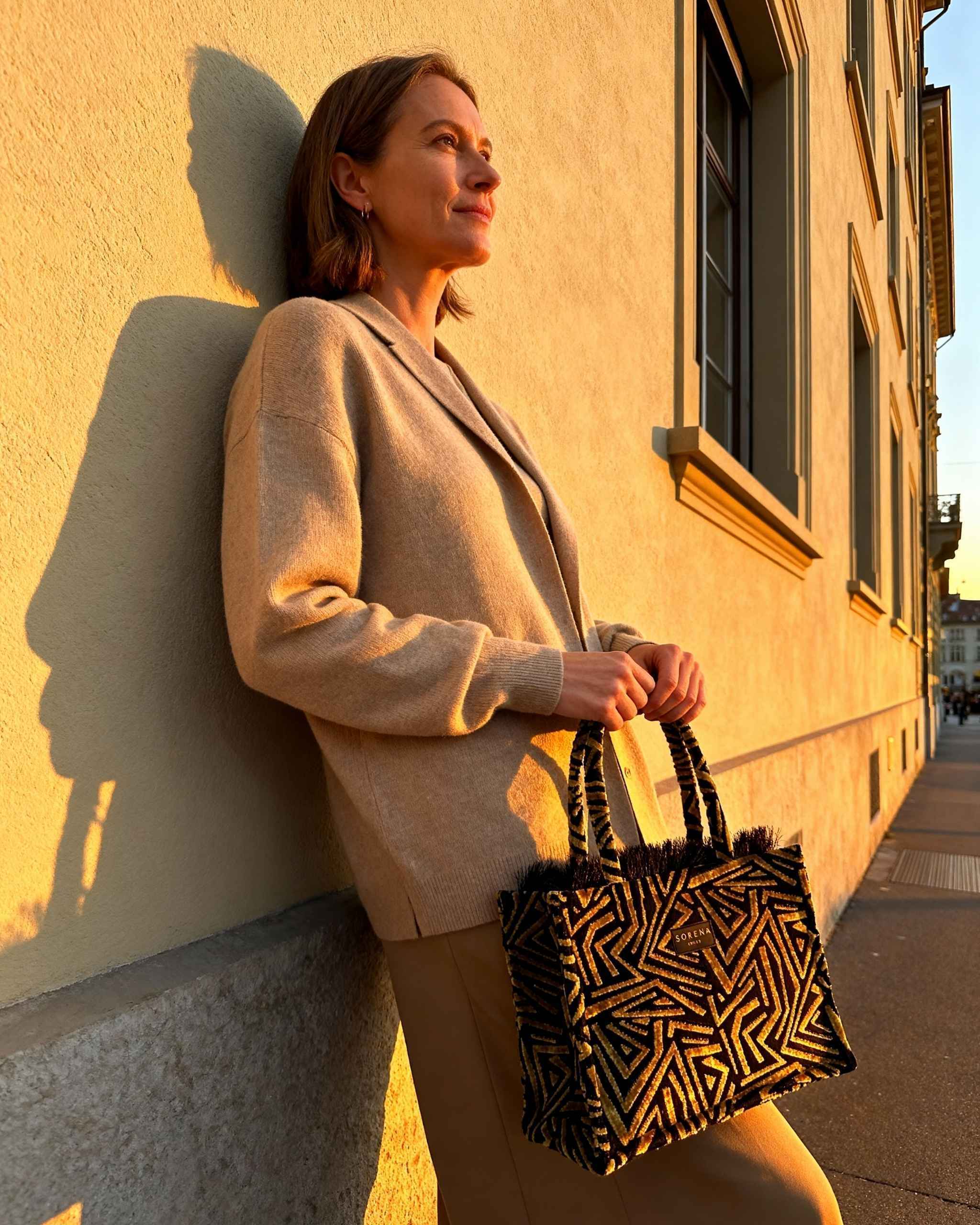 Model trägt Shopper von sorena Greece in Gold und Schwarz in der Stadt, perfekte Tasche für City-Trip