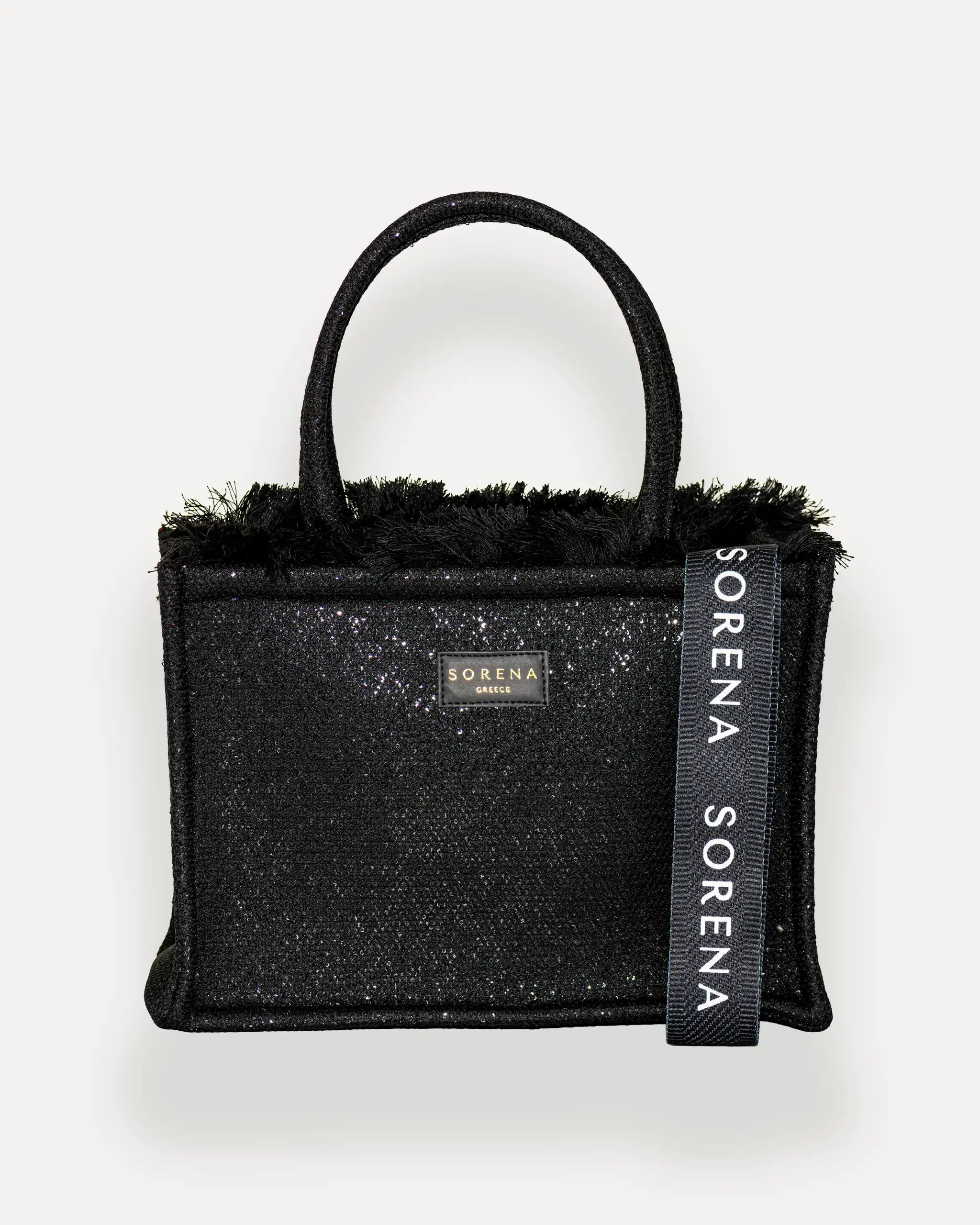 Frontansicht der Sorena Greece Medium Tote Bag – schwarze Glitzerstruktur, Fransen, Label und vertikales Branding sichtbar, hochwertige shopper tasche damen schweiz mit Designfokus.