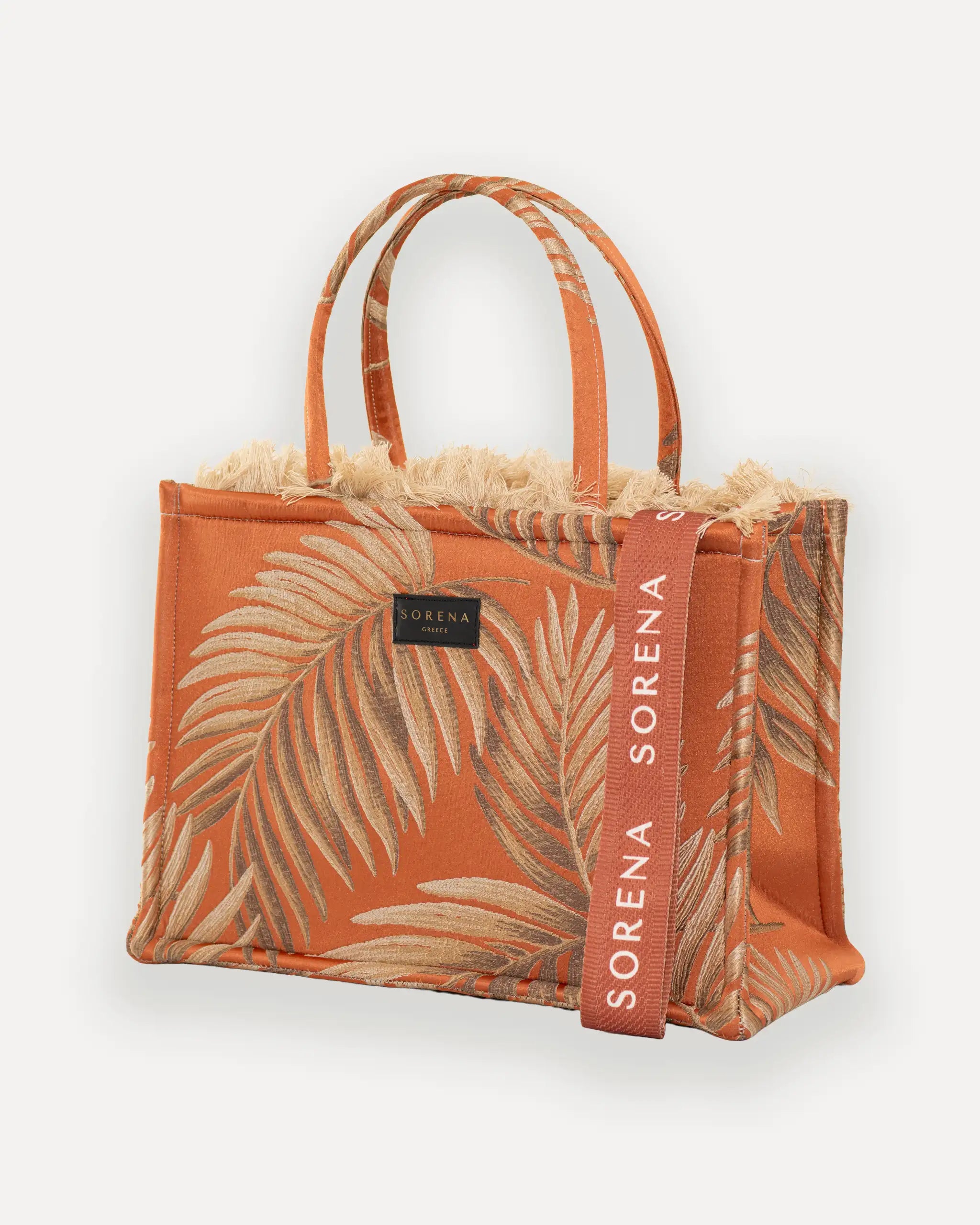 Sorena Greece Large Tote Bag linksseitig getragen – strukturierte shopper tasche mit Fransen und orangem „SORENA“-Band, ideale tasche für dinner und city looks, bags schweiz mit Designfokus.