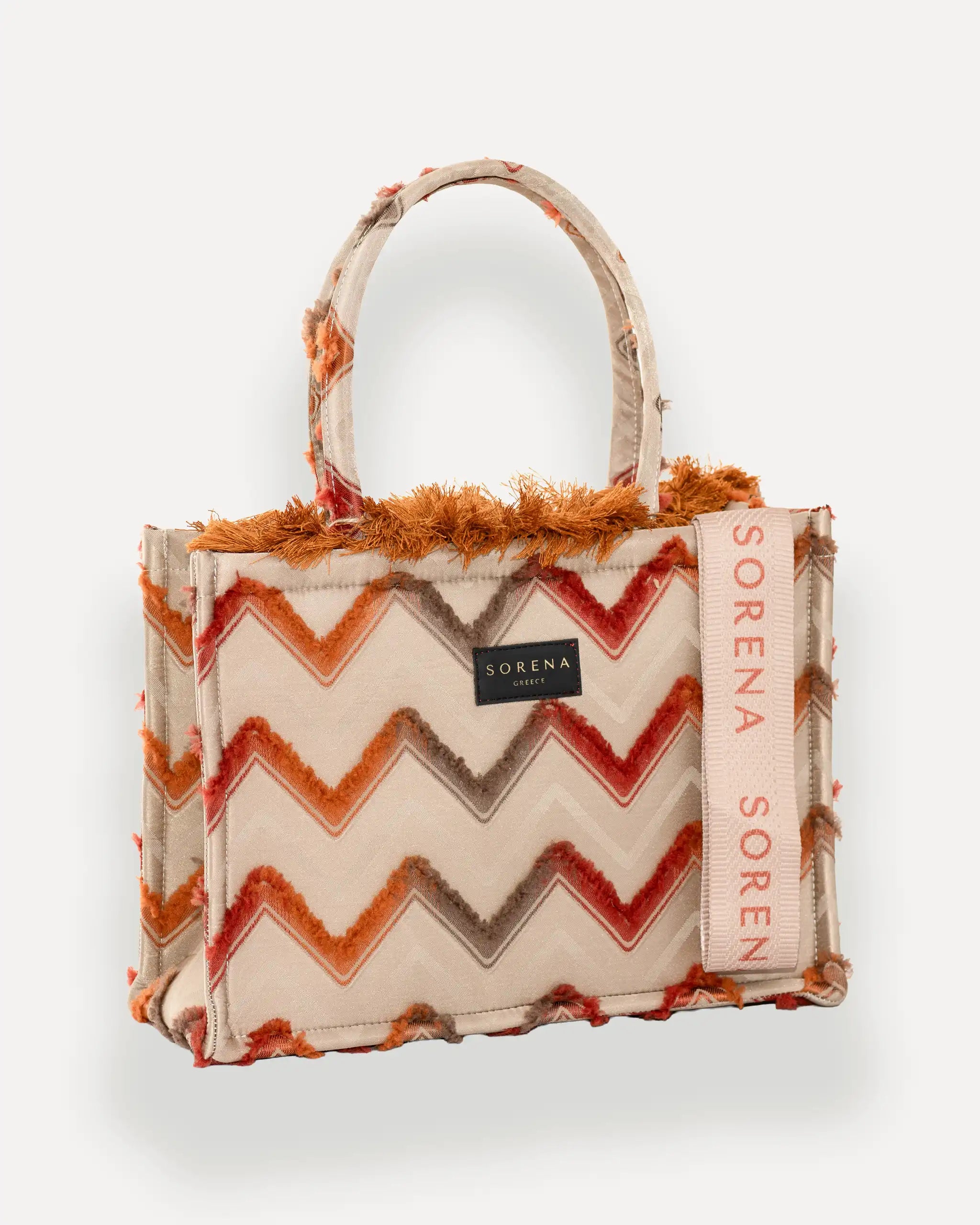 Female Model mit Sorena Greece Tote Bag rechtsseitig getragen – stylische tote bag mit geometrischem Muster in Rot, Orange und Beige, perfekte handtasche für City-Looks, limitierte designer bags schweiz.