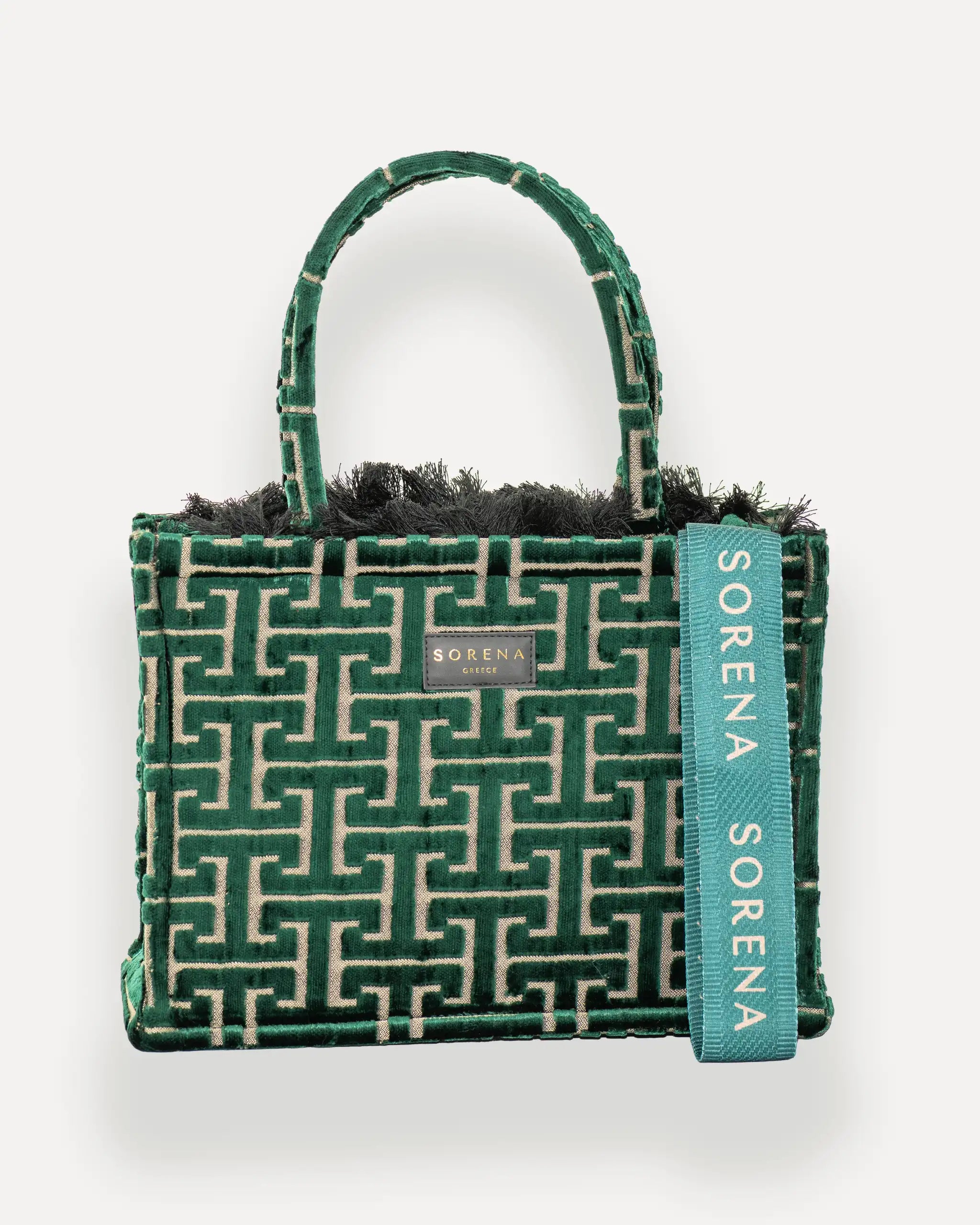 Frontansicht der Sorena Greece Medium Tote Bag – geometrisches Muster in Grün und Beige, Fransen, Label und vertikales Branding sichtbar, hochwertige shopper tasche damen schweiz mit Designfokus.