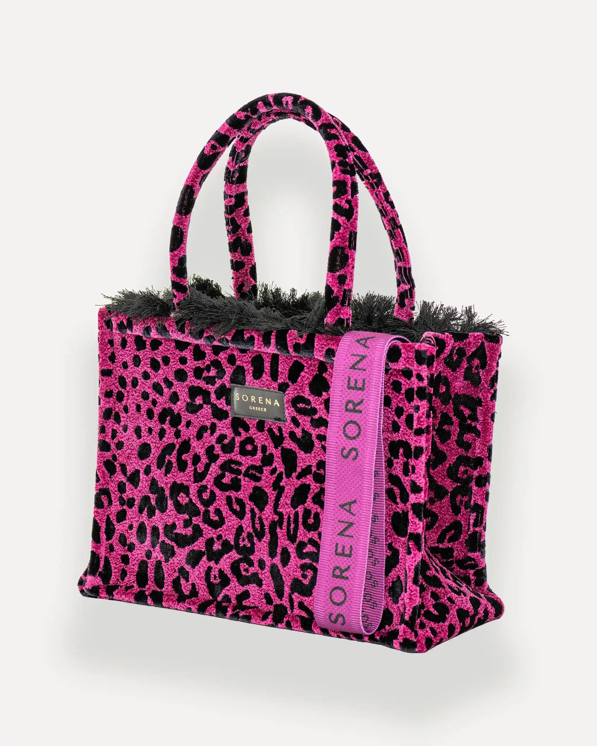 Sorena Greece Medium Tote Bag linksseitig getragen – leo shopper bag mit Fransen und vertikalem „SORENA“-Band, ideale tasche für dinner und city looks, bags schweiz mit Statement-Design.