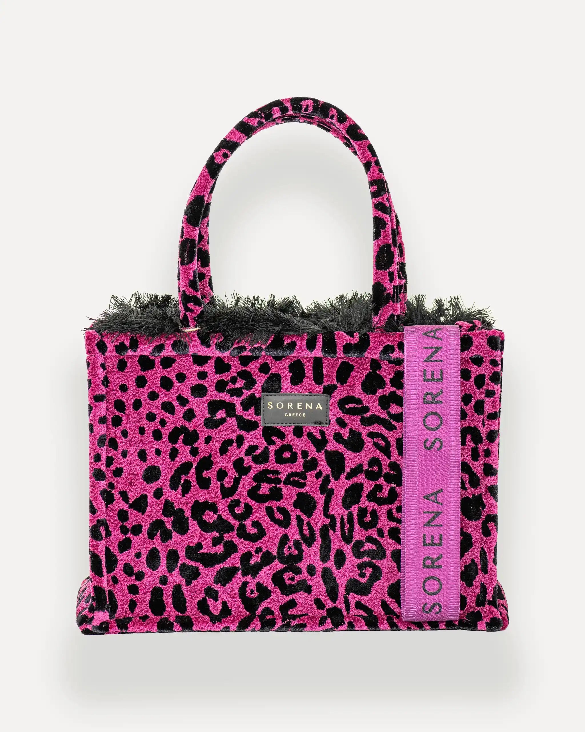 Frontansicht der Sorena Greece Medium Tote Bag – pink-schwarzes Leopard-Muster, Fransen, Label und vertikales Branding sichtbar, hochwertige shopper tasche damen schweiz mit Designfokus.