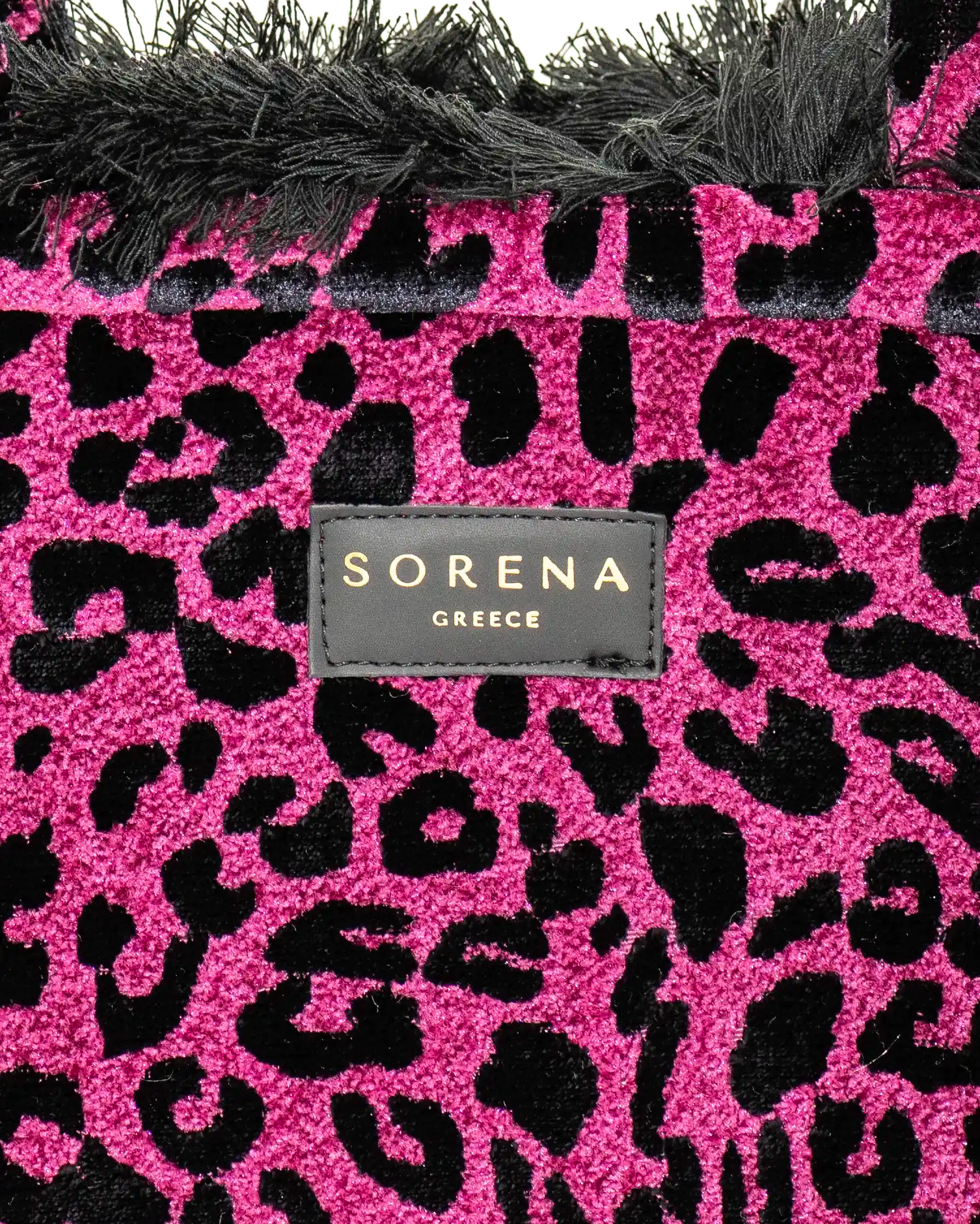 Detailansicht der Sorena Greece Tote Bag – strukturierte Oberfläche mit leo Print in Magenta und Schwarz, Label „SORENA GREECE“, vertikales Band mit Branding, perfekte tote bag für Business & Freizeit, handtaschen damen mit Statement.