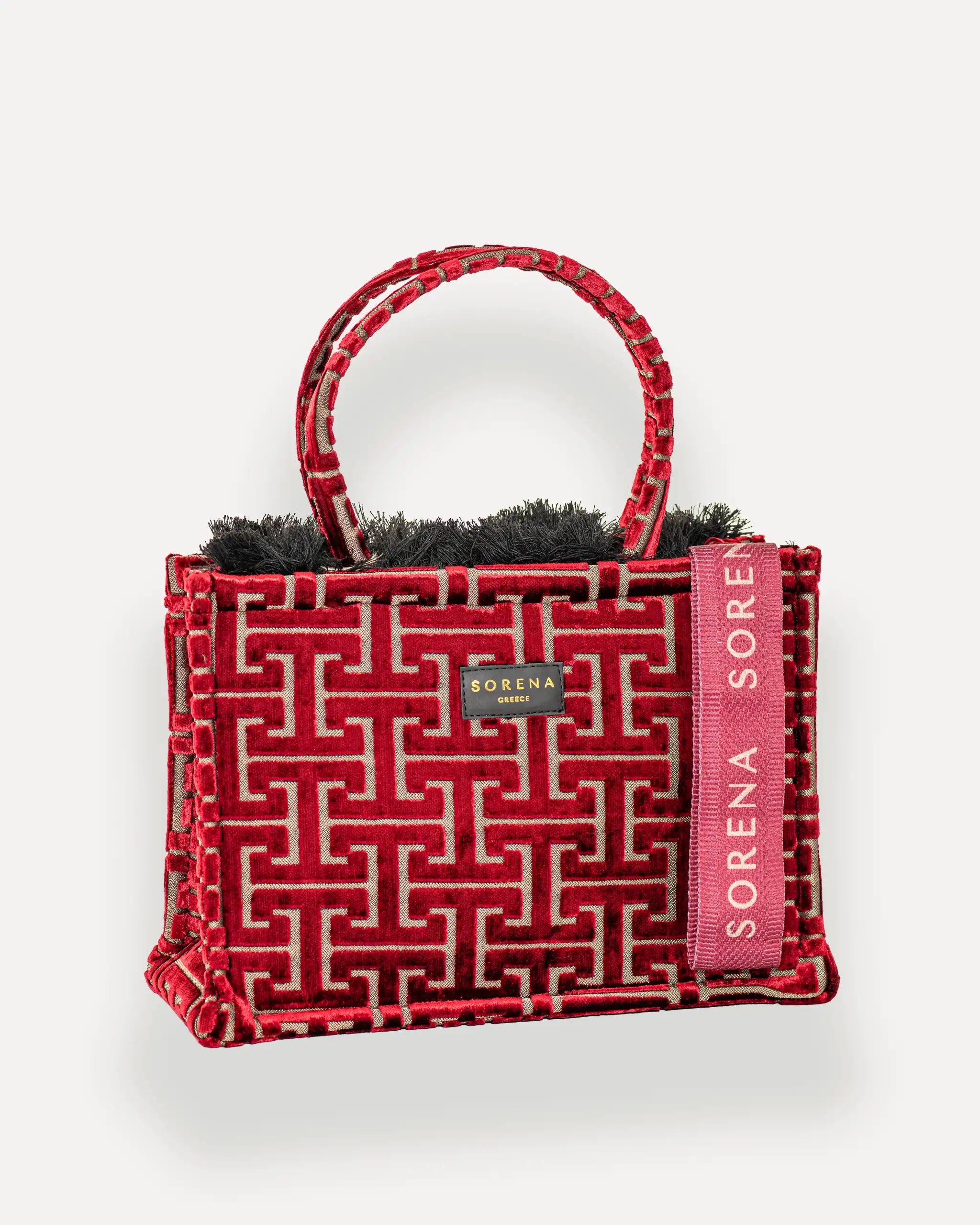 Female Model mit Sorena Greece Tote Bag rechtsseitig getragen – stylische tote bag mit rotem Muster und rosa Branding, perfekte handtasche für City-Looks, limitierte designer bags schweiz.