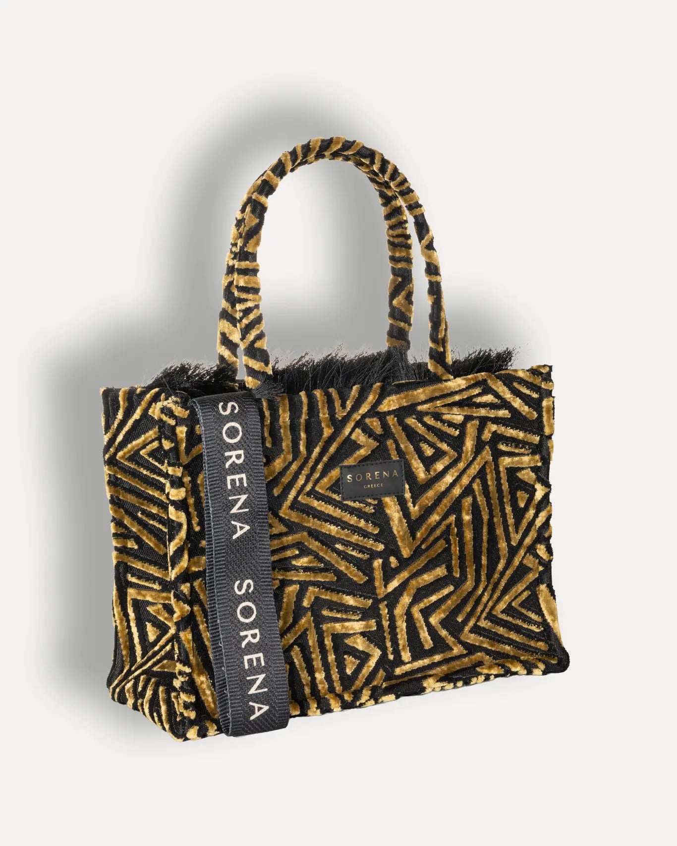 Rechte Seite Sorena Greece Sylvana Medium Tote Bag, schwarzer Grundstoff goldocker geometrisches Samtvelour Muster schwarze Fransen Sorena Greece Label frontal, handgefertigter veganer Shopper
