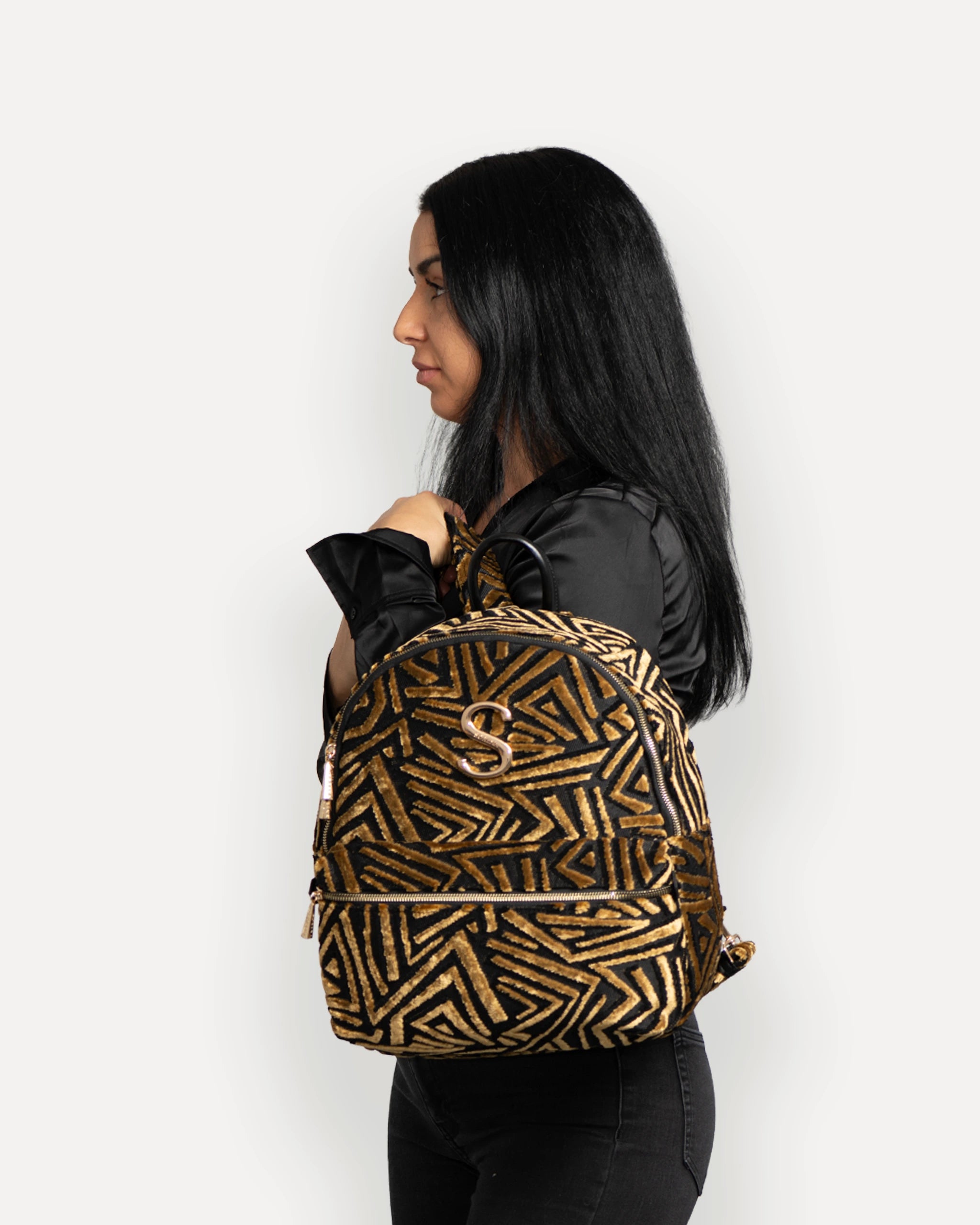 Model mit SORENA Designer Rucksack in Gold-Schwarz – veganer rucksack für Damen, handgemacht mit mediterranem Flair. Stylische rucksäcke nachhaltig schweiz mit schneller Lieferung.