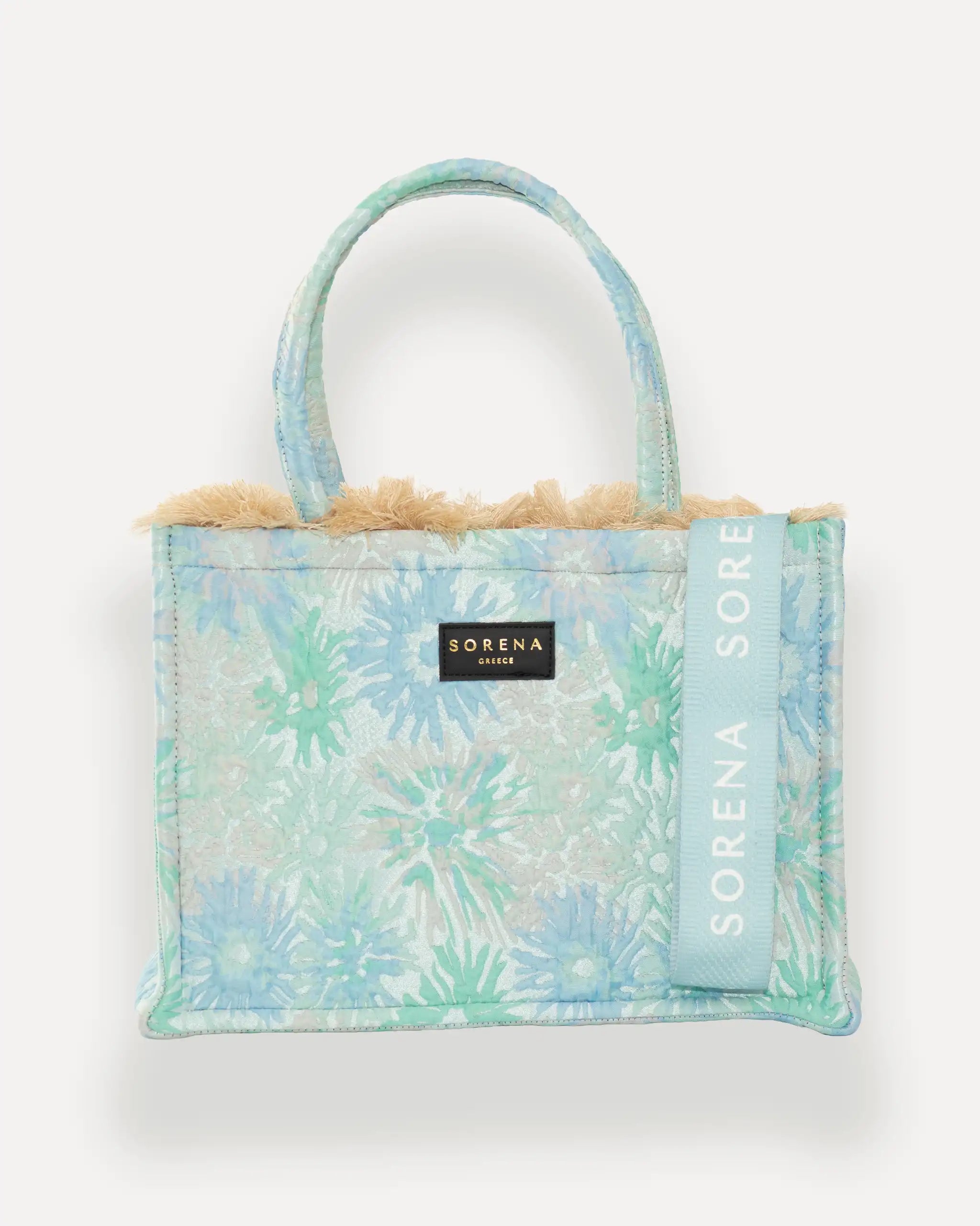 Frontansicht der Sorena Greece Medium Tote Bag – florales Muster in Blau, Grün und Weiß, Teddy-Rand, Label und vertikales Branding sichtbar, hochwertige shopper tasche damen schweiz mit Designfokus.