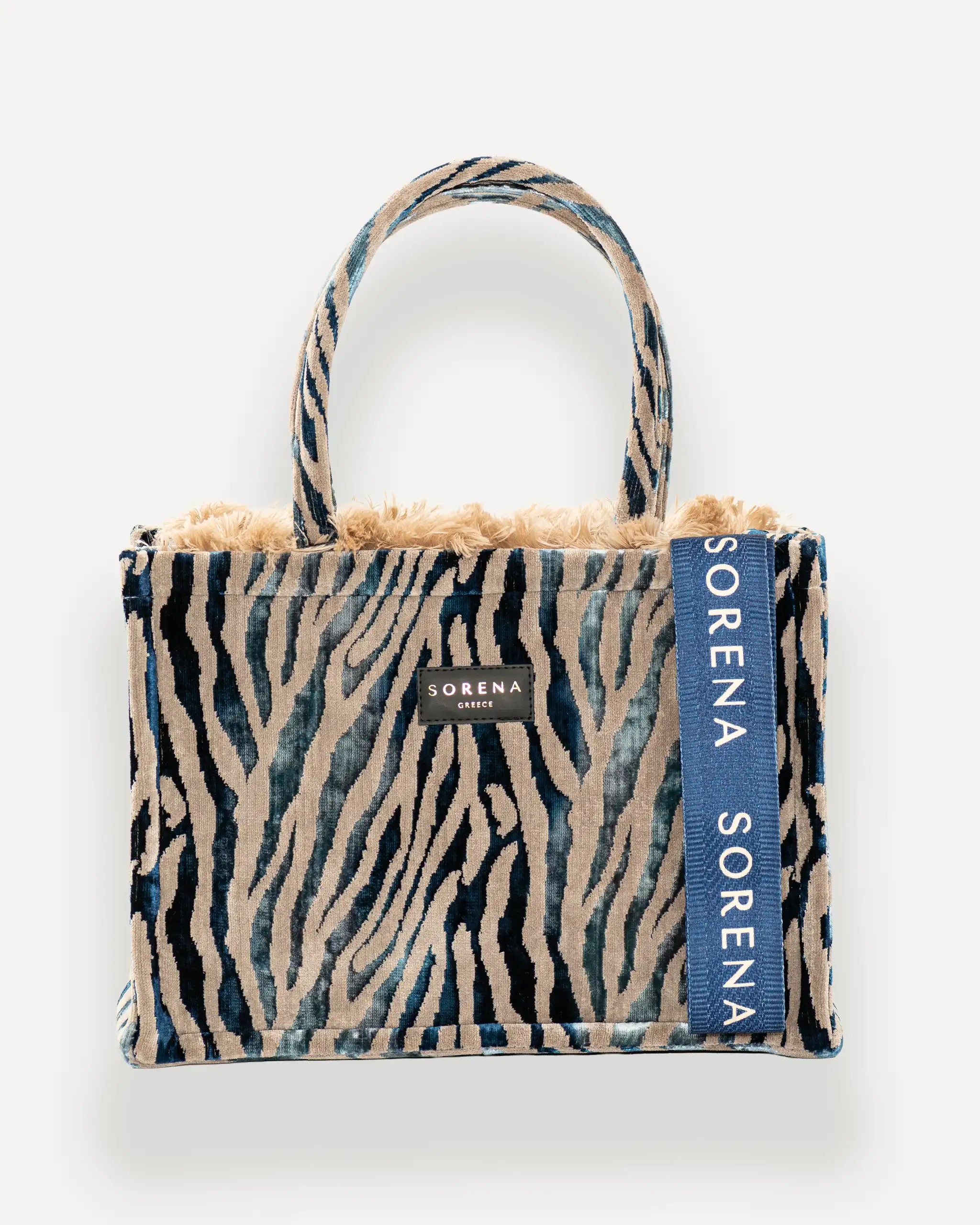 Frontansicht der Sorena Greece Medium Tote Bag – Tigerstreifen-Muster, Fellrand, Label und vertikales Branding sichtbar, hochwertige shopper tasche damen schweiz mit Designfokus.