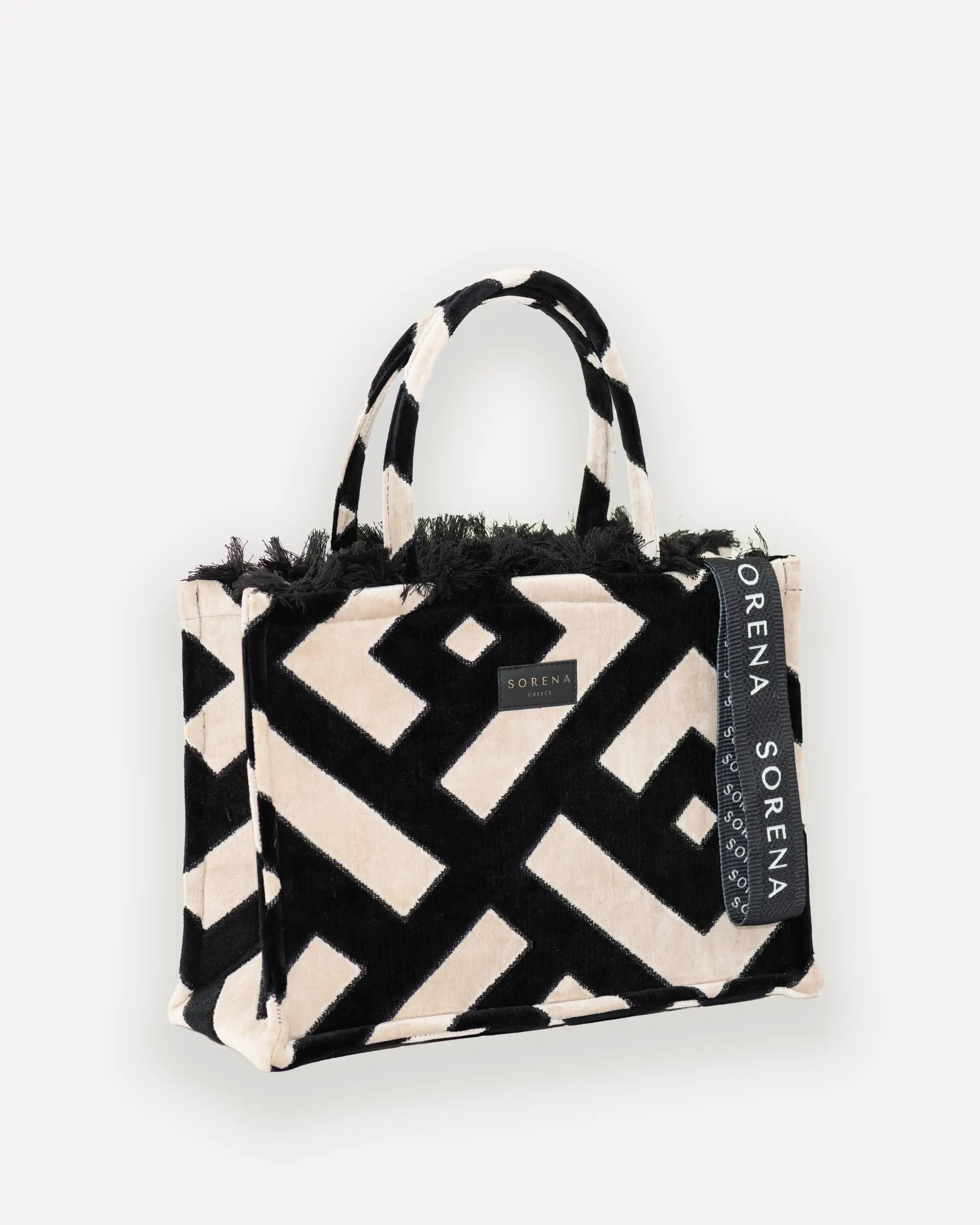 Female Model mit Sorena Greece Large Tote Bag rechtsseitig getragen – stylische tote bag mit geometrischem Print und Fransen, perfekte tasche gross für City-Looks, limitierte designer bags schweiz.